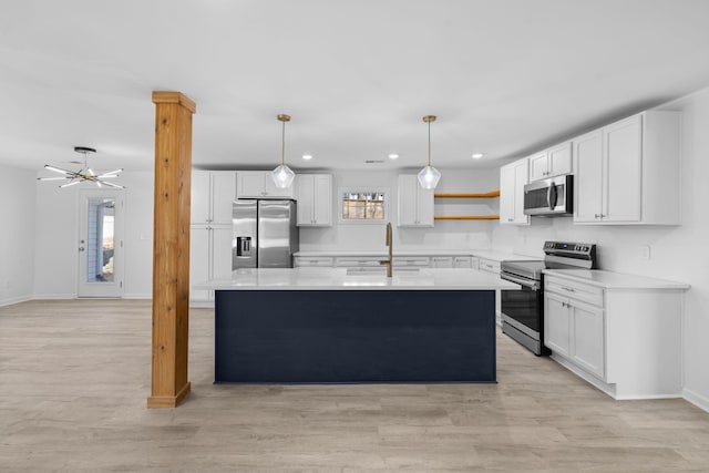 kitchen featuring a center island with sink, white cabinetry, and stainless steel appliances