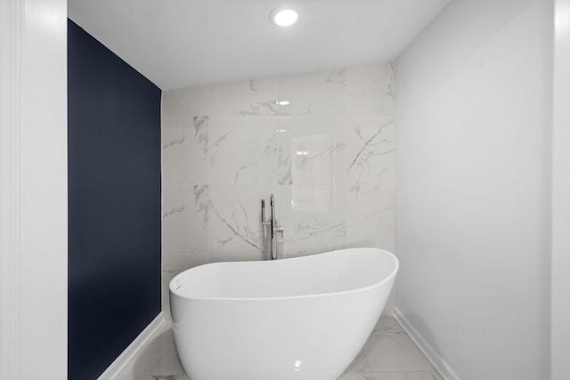 bathroom with recessed lighting, baseboards, a soaking tub, and marble finish floor