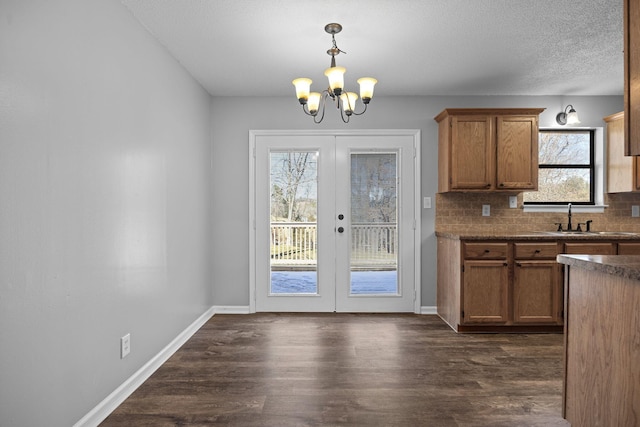 interior space with a sink, french doors, a chandelier, and dark wood-style flooring