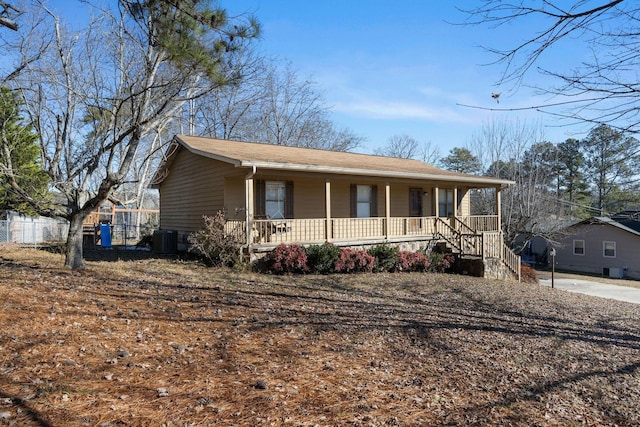 view of front facade with a porch, central AC, and fence