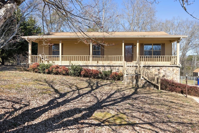 ranch-style house featuring stone siding and covered porch