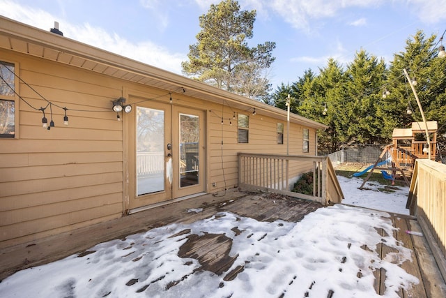 wooden deck with french doors, a playground, and fence