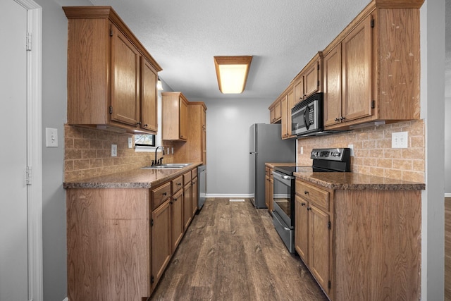 kitchen featuring baseboards, dark wood-style flooring, a sink, appliances with stainless steel finishes, and backsplash