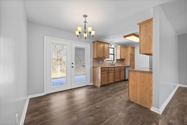 kitchen with tasteful backsplash, stainless steel dishwasher, french doors, an inviting chandelier, and dark wood-style flooring