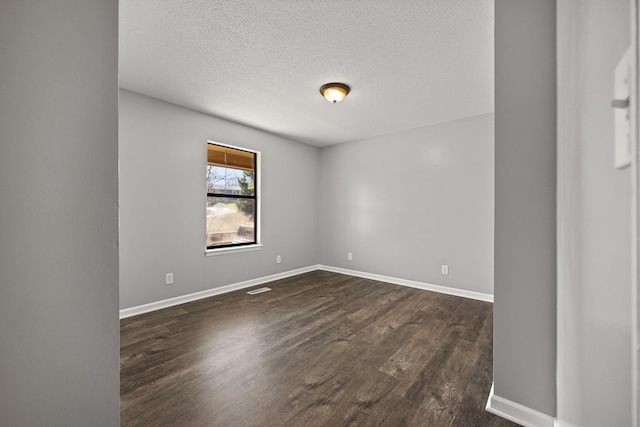 unfurnished room with baseboards, a textured ceiling, and dark wood-style flooring