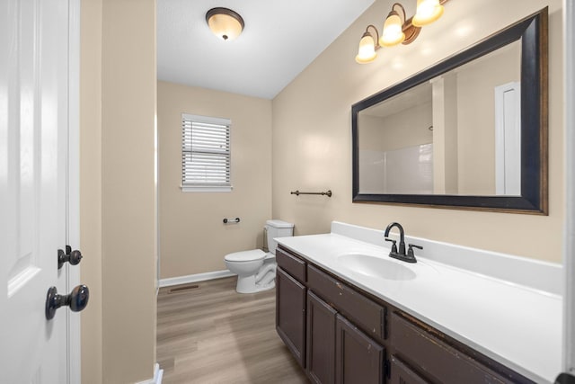 full bathroom featuring visible vents, baseboards, toilet, wood finished floors, and vanity