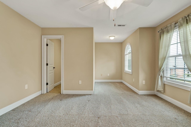 unfurnished bedroom featuring multiple windows, carpet flooring, baseboards, and visible vents