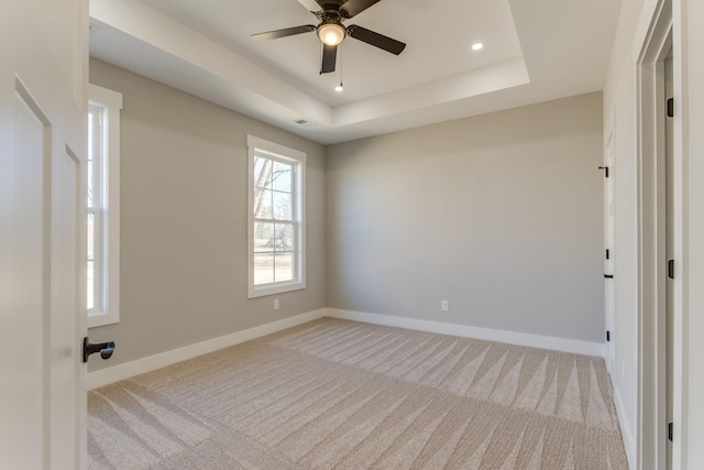 carpeted empty room featuring visible vents, baseboards, ceiling fan, a tray ceiling, and recessed lighting