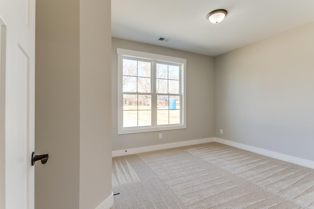 carpeted spare room featuring visible vents and baseboards