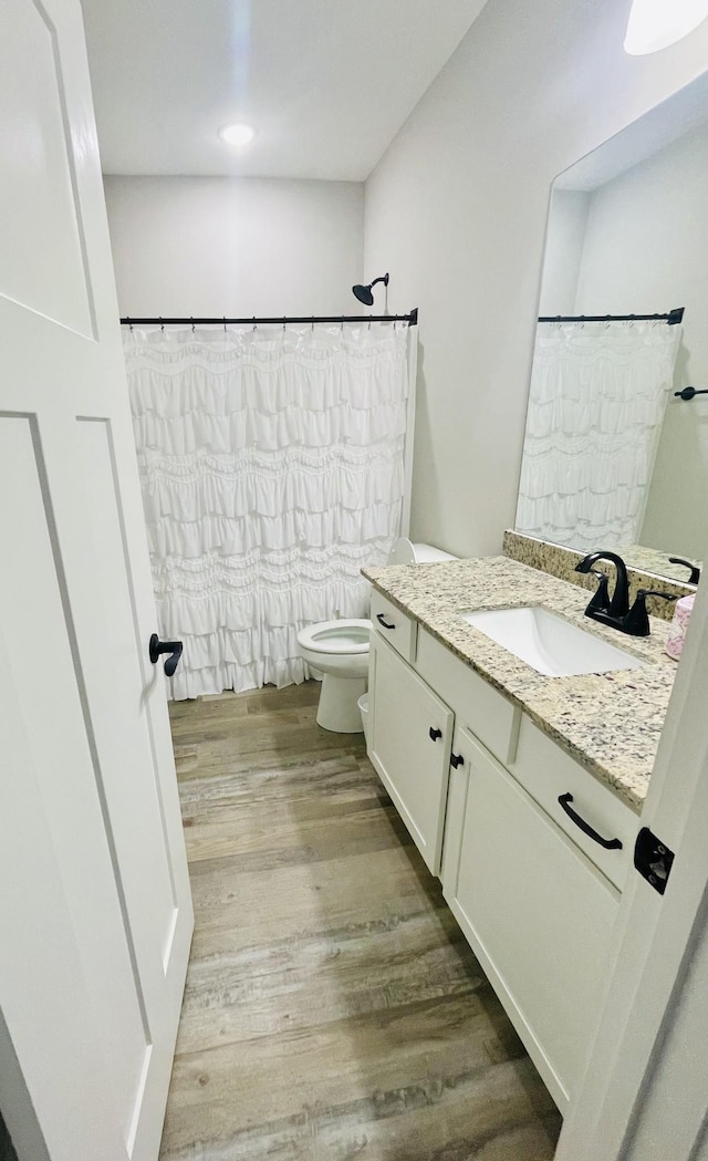 bathroom featuring vanity, a shower with curtain, toilet, and wood finished floors