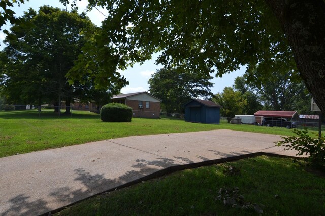 exterior space featuring an outbuilding, a storage unit, and fence