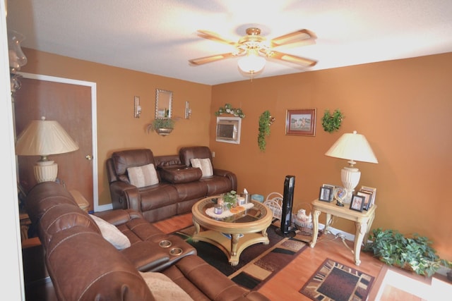 living area with baseboards, a ceiling fan, and wood finished floors