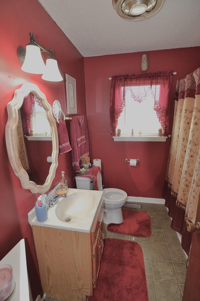 full bath with vanity, tile patterned floors, toilet, and a textured ceiling