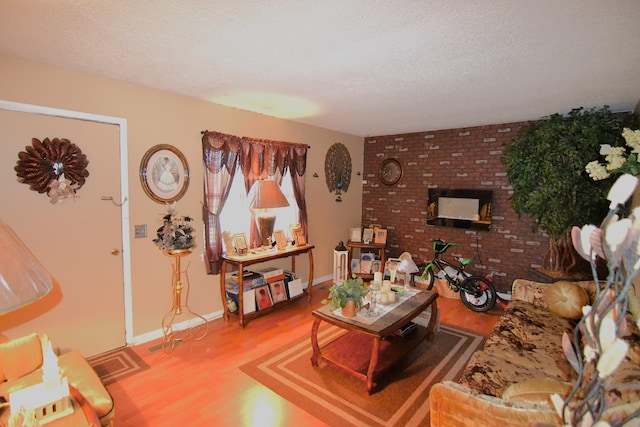 living area featuring light wood-style flooring, baseboards, and a textured ceiling