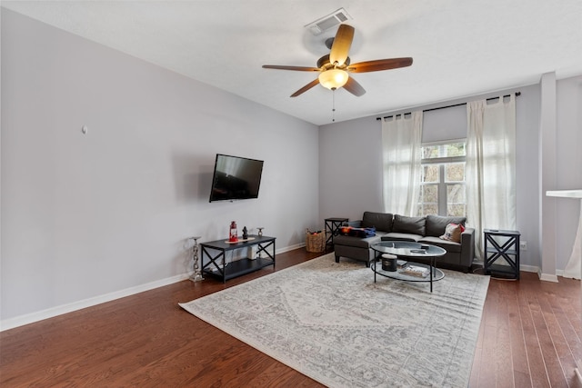 living room featuring visible vents, a ceiling fan, dark wood-type flooring, and baseboards