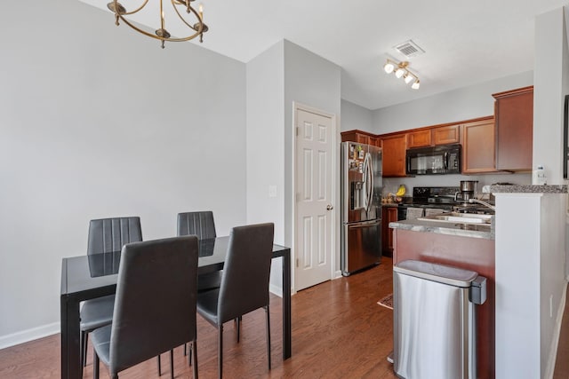 kitchen with visible vents, black appliances, a sink, dark wood-style floors, and a chandelier