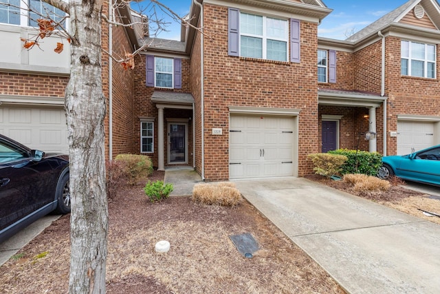 view of property with a garage, brick siding, and driveway