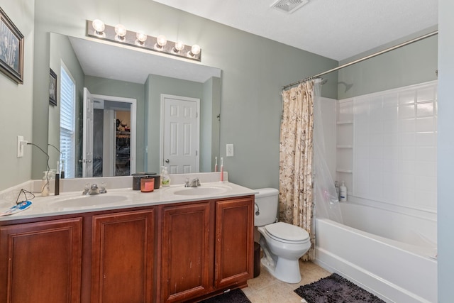 bathroom with double vanity, visible vents, toilet, and a sink