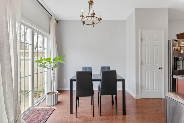 dining area featuring wood finished floors, baseboards, and a chandelier