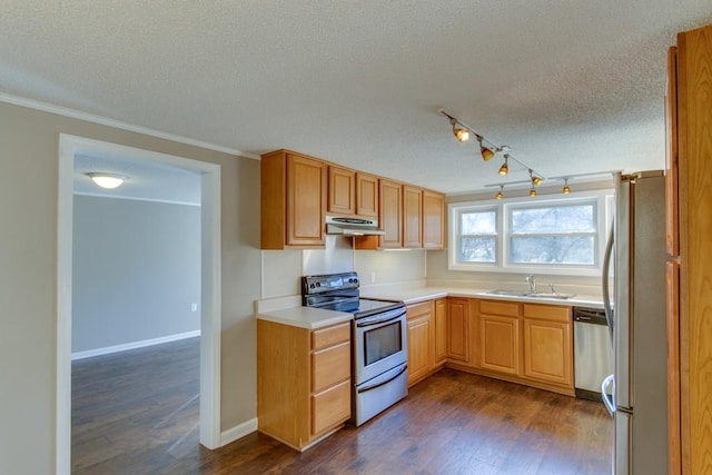 kitchen with dark wood-type flooring, a sink, a textured ceiling, stainless steel appliances, and light countertops