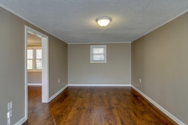 spare room featuring wood finished floors, baseboards, a wealth of natural light, and ornamental molding