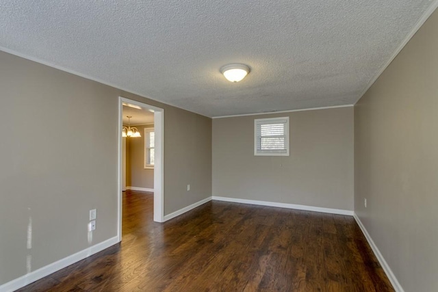 unfurnished room with dark wood finished floors, crown molding, baseboards, and a textured ceiling