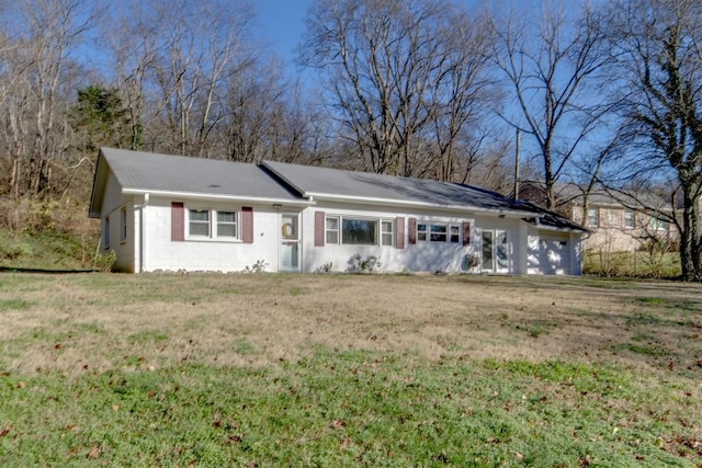 ranch-style house featuring concrete block siding and a front yard