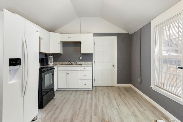 kitchen featuring white cabinets, black electric range oven, white fridge with ice dispenser, and a sink