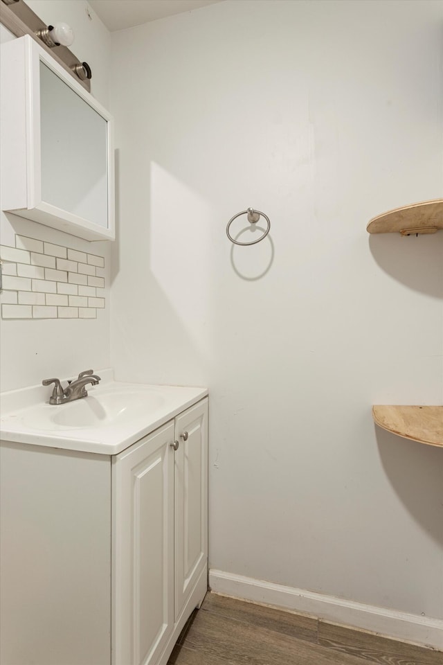 bathroom with vanity, wood finished floors, and baseboards