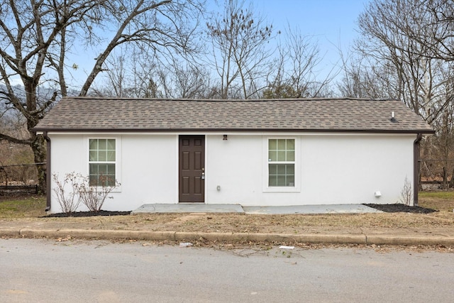 ranch-style house featuring stucco siding, fence, and a shingled roof