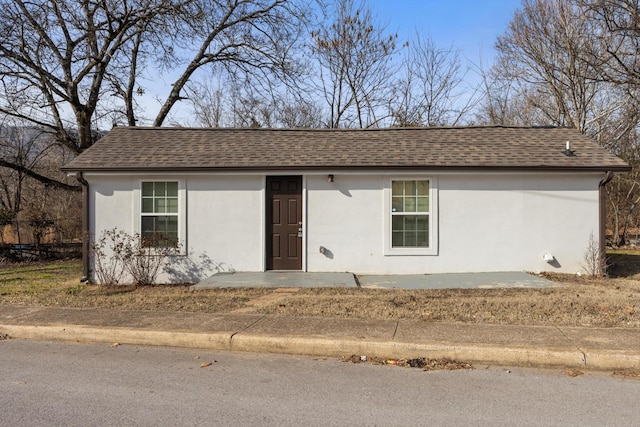 ranch-style home with stucco siding and a shingled roof