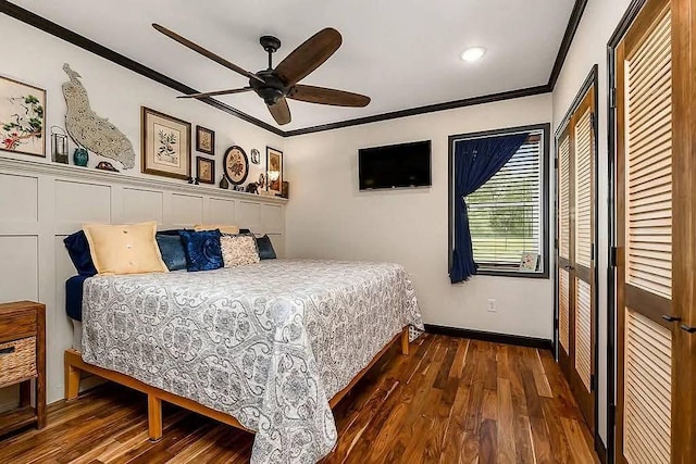 bedroom featuring a ceiling fan, wood finished floors, baseboards, ornamental molding, and a closet