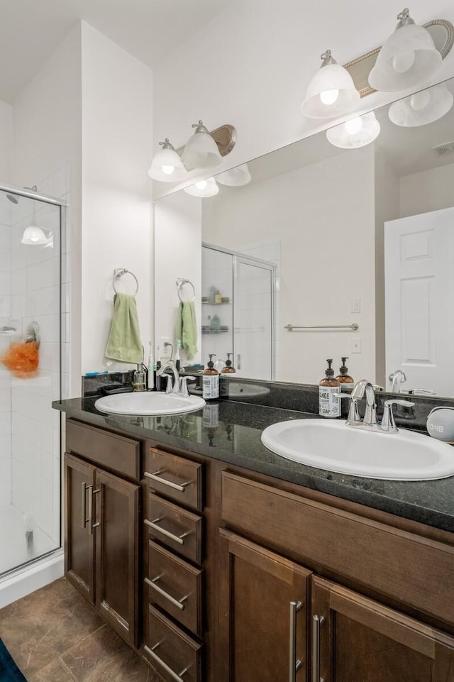 full bath with double vanity, a stall shower, and a sink