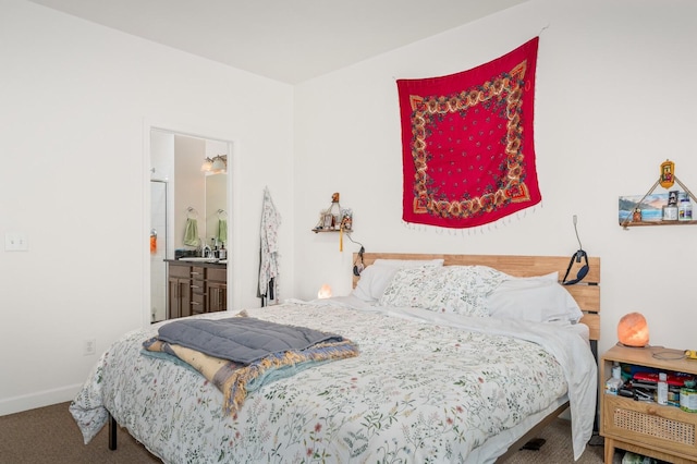 bedroom with ensuite bath, baseboards, and carpet floors