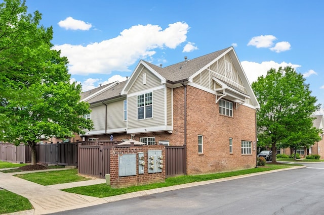 view of property exterior featuring a gate, brick siding, and a fenced front yard