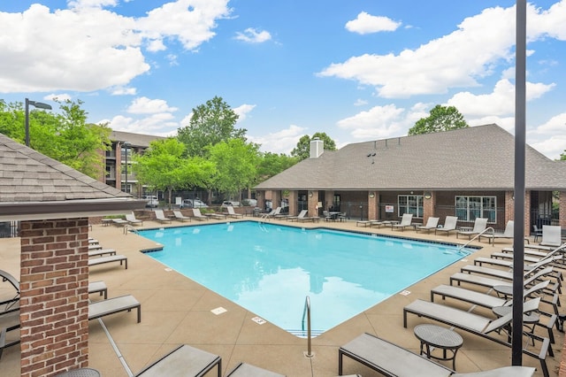 pool with a patio and fence