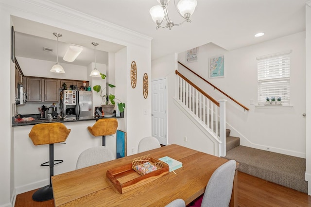 dining space with stairs, baseboards, and wood finished floors