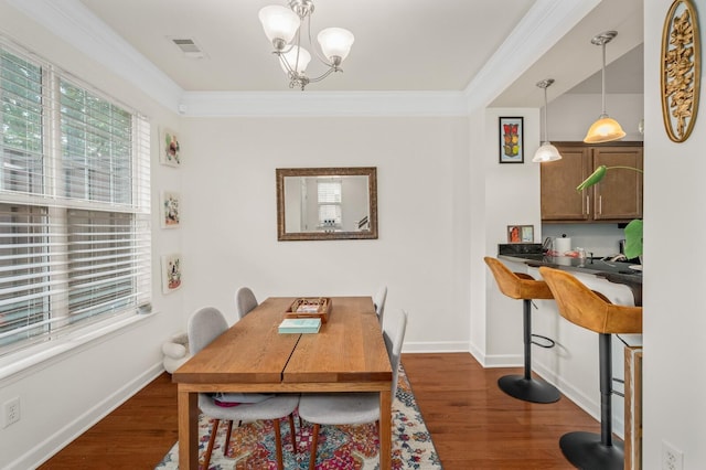 dining area with visible vents, dark wood-type flooring, and ornamental molding