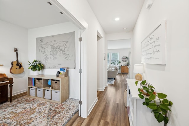 hall with baseboards and wood finished floors