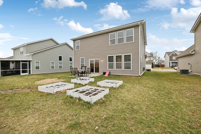 back of property with central air condition unit, a lawn, a vegetable garden, and a sunroom