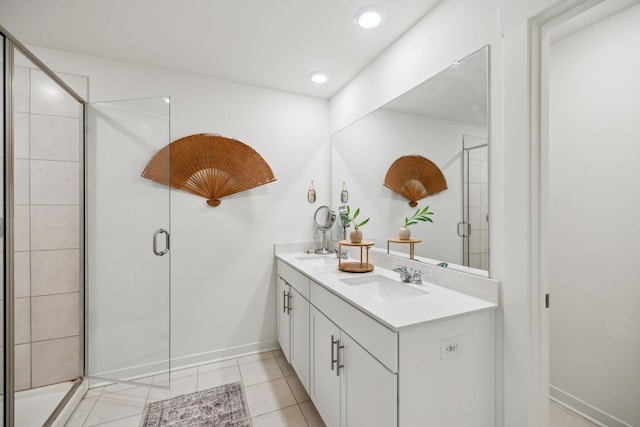 full bath with double vanity, tile patterned flooring, a shower stall, and a sink