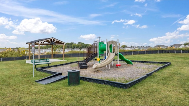 communal playground featuring a lawn and fence