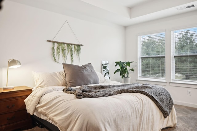 carpeted bedroom with visible vents, multiple windows, and baseboards