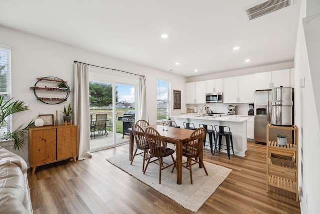 dining area featuring recessed lighting, visible vents, and light wood finished floors