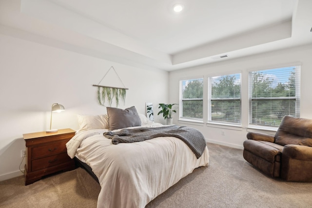 bedroom featuring baseboards, visible vents, a raised ceiling, and light carpet