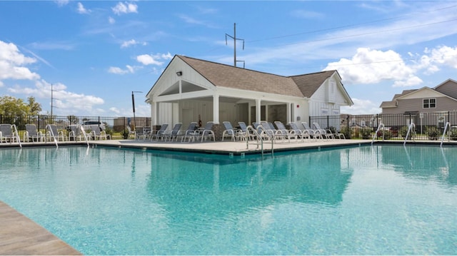 community pool with a patio area and fence