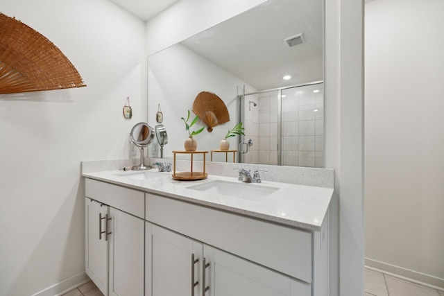 full bath with visible vents, double vanity, a stall shower, a sink, and tile patterned floors