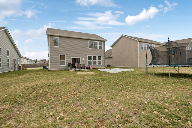 rear view of house featuring a patio area, a lawn, and a trampoline