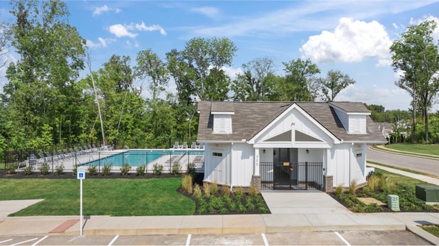 view of property featuring a fenced front yard and a community pool