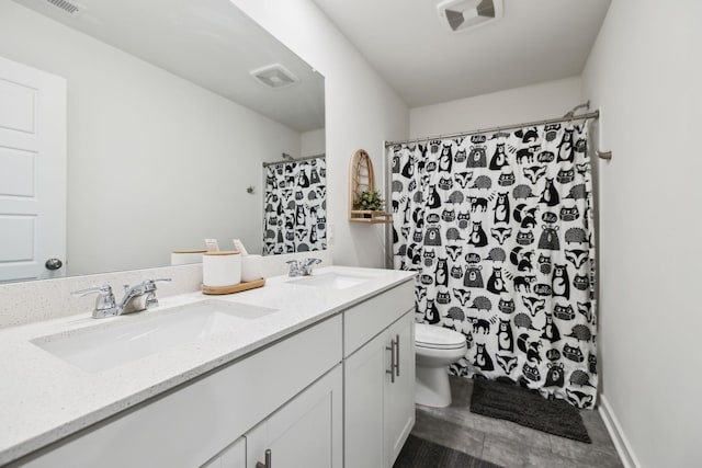 bathroom with double vanity, toilet, visible vents, and a sink